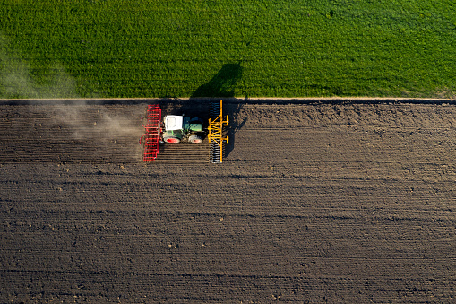 The tractor plows a field, aerial view.