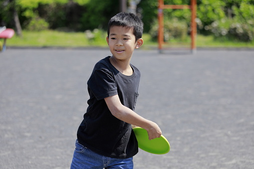 Japanese boy playing flying disc (fifth grade at elementary school)