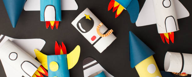 istock School kindergarten crafts, paper spaceship, shuttle, astronaut on black background with copy space for text. Party concept handcraft, diy, creative idea from toilet tube, recycle 1222878329