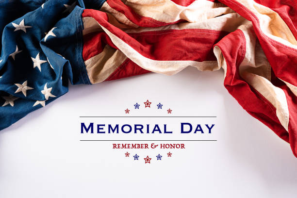 istock Happy Memorial Day. American flags with the text REMEMBER & HONOR against a white background. May 25. 1222879181