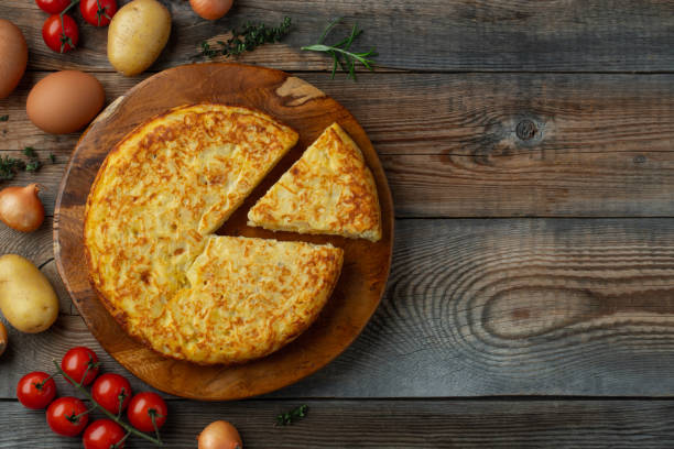 Spanish omelette with potatoes and onion, typical Spanish cuisine. Tortilla espanola. Rustic dark background. Top view with copy space Spanish omelette with potatoes and onion, typical Spanish cuisine. Tortilla espanola. Rustic dark background. Top view with copy space. omelet rustic food food and drink stock pictures, royalty-free photos & images