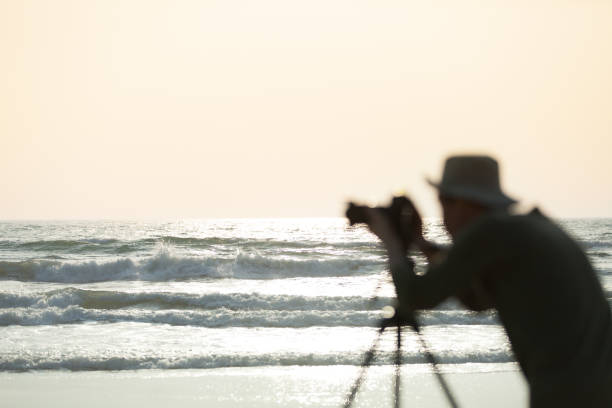 Photographer on the beach shooting model.