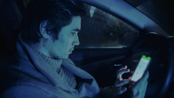 istock Handsome man sitting in the car and using mobile phone 1222895464