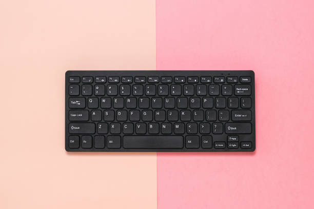 istock Black wireless keyboard on pink and red background. 1222896325
