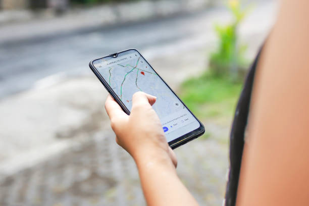 Checking Covid - 19 community mobility reports on Google maps Bali,Indonesia, December 15, 2019 - Close up young woman using Google maps to check Covid - 19 community mobility reports to combat the virus spreading crowdsourced taxi photos stock pictures, royalty-free photos & images