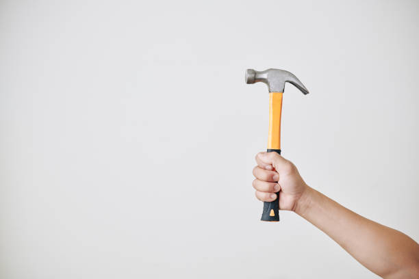 reparaturarbeiter hält hammer - work tool hand tool home improvement nail stock-fotos und bilder