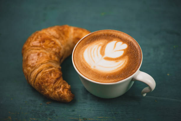 istock Latte coffee in a cup,Latte coffee and bread on indigo wood 1222908390