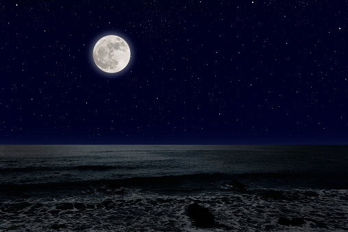 Full moon rising over the sea with copy space.