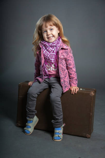 istock Little girl sits on large suitcase 1222913967