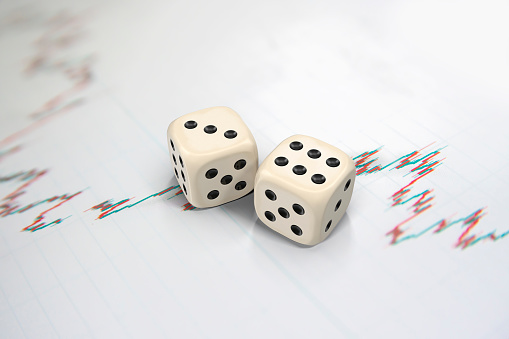 Business, finance and volatility concept; 3D gold dice objects on white background financial data screen with copy space.