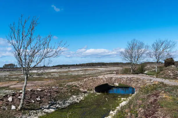 Old limestone stonebridge in a plain landscape in the nature reserve Kvinnsgrota on the swedish island Oland