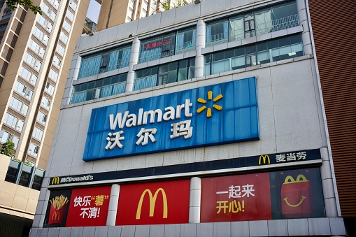 Shenzhen, Guangdong Province, China - 28 December 2019: Cityscape of billboard with Walmart and McDonalds outside a shopping mall in town.
