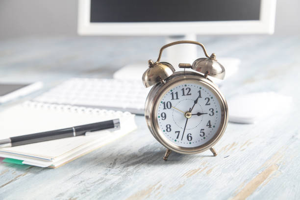 istock Alarm clock with business object on the desk. 1222927812