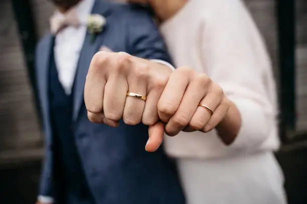 Newlywed couple showing their golden wedding rings