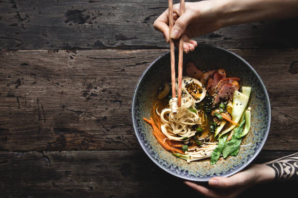 istock Eating ramen soup with noodles, pork, marinated egg and vegetables, top view. 1222930577