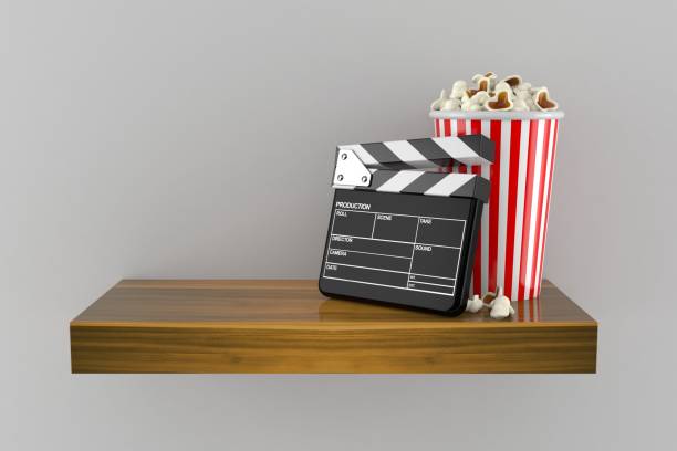 istock Popcorn and clapboard on wooden shelf 1222935856