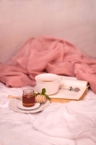 istock Cup of hot tea with honey and a book 1222935928