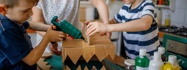 istock Mom and kids making a cardboard dinosaur costume 1222936169