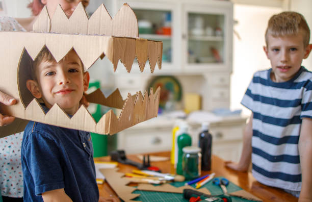 istock Smiling boy wearing a cardboard dinosaur costume 1222936173