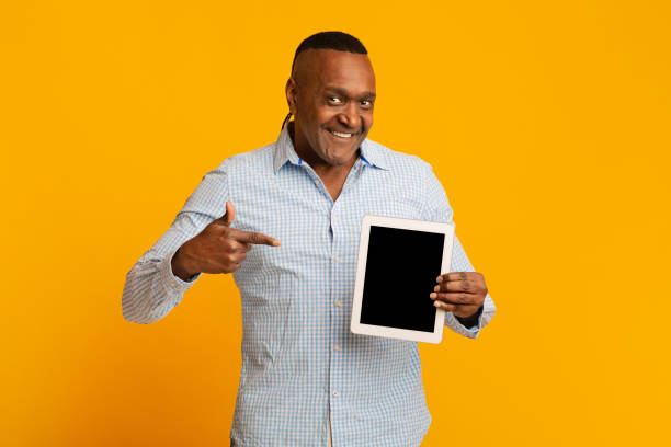 istock Middle aged black man pointing finger at blank digital tablet screen 1222937407