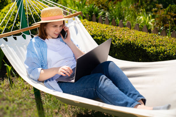 istock woman lies in hammock and working on computer 1222938675