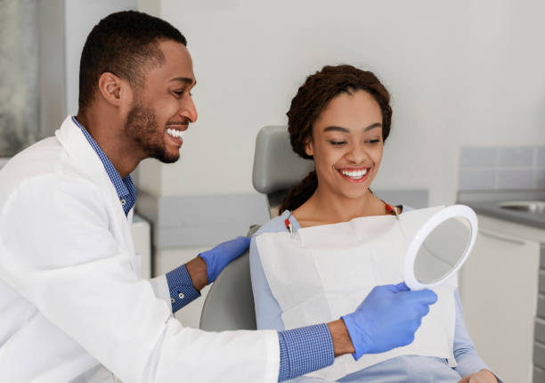 istock Friendly black dentist giving mirror to his happy patient 1222938843