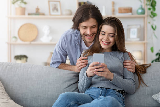istock Cheerful couple watching photos on modern phone 1222939002