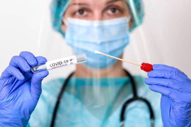 medical healthcare holding covid-19 , coronavirus swab collection kit, wearing ppe protective suit mask gloves, test tube for taking op np patient specimen sample,pcr dna testing protocol process - protective suit fotos imagens e fotografias de stock