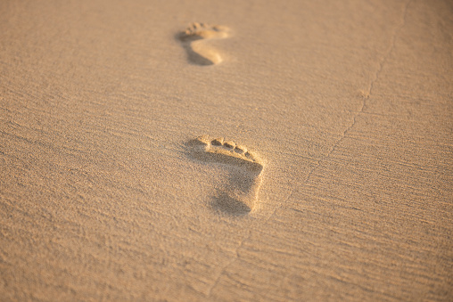 footprints on a beautiful morning sunset sandy beach in sand