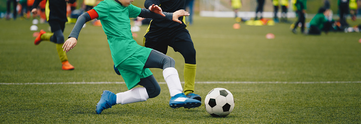 Junior Football Players in a Duel. Players Running Fast After Soccer Ball. School Sports Competetion Between Two Soccer Teams. Soccer Horizontal Background
