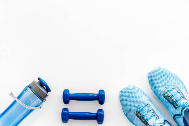 istock Workout flat-lay with dumbbells, water and sneakers on white background top-down copy space 1222942552