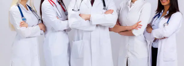 medicine. multinational people - doctor, nurse and surgeon. a group of faceless doctors. A team of young doctors in white robes. A staff of medical students of different nationalities.