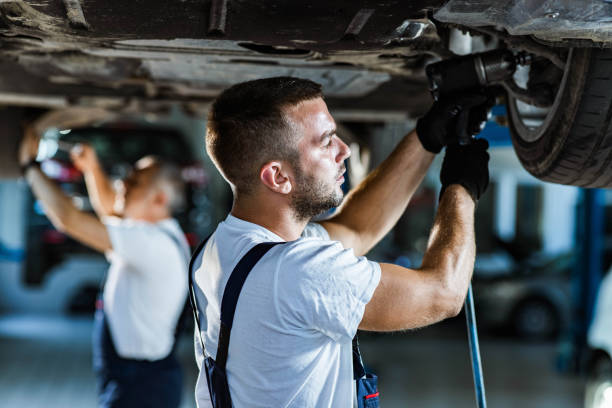 istock Young mechanic changing tire on a car in a workshop. 1222942790