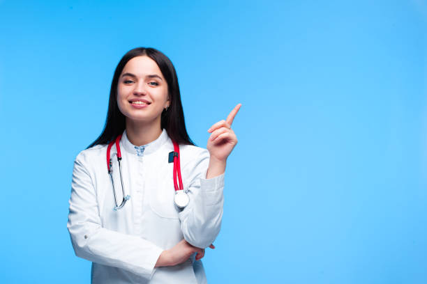 medical concept of beautiful female doctor in white coat with phonendoscope. medical student general practitioner. woman hospital worker looking at camera and smiling, studio, gray background - healthcare and medicine nurse doctor general practitioner imagens e fotografias de stock