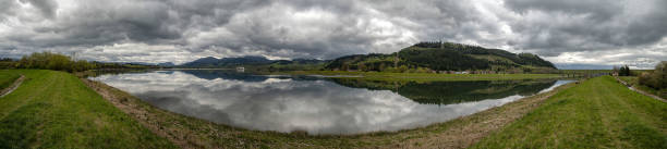 istock Reflection of dark clouds in lake. Panoramic landscape 1222945701