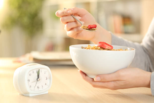istock Woman hands eating cereal bowl after intermittent fasting 1222945975