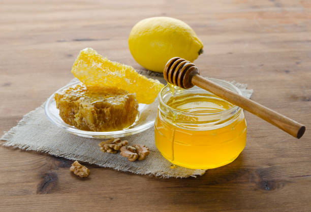 Honey Composition with Fresh Honey, Dipper and Honeycomb on Wooden Table Honey Composition with Fresh Liquid Honey Dipping in Glass Jar from Dipper Spoon and Honeycomb on Old Wooden Table. Beekeeping Harvest Set. Tasty Delicious and Nutritious Honey honey jar liquid gourmet stock pictures, royalty-free photos & images