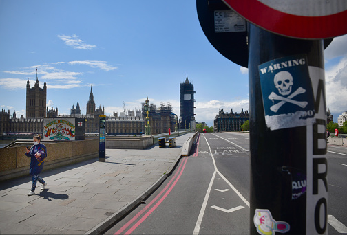 Westminster bridge and abandoned during the Corvid 19 pandemic lock down - a foreground fly post advert of a skull and crossbones