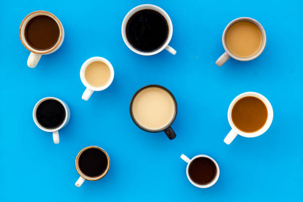 istock Many cups of coffee on blue desk top view 1222947268