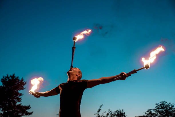 de kunstenaar die van het vuur lichte show bij nacht doet - jongleren stockfoto's en -beelden