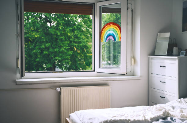 Open window in room with green trees on background. Painting rainbow on window. Open window in room with green trees on background. Painting rainbow on window. Rainbow painted with paints on glass is a symbol for many meanings. Feeling of freshness, spring, fresh air, revive. drawing of spring free stock pictures, royalty-free photos & images