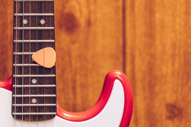 istock pink pick on electric guitar fretboard 1222947736