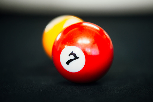 2 red and yellow pool balls on a pool table used to play pool.