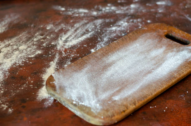 istock A kitchen table with a wooden cutting board is covered in flour. 1222950258