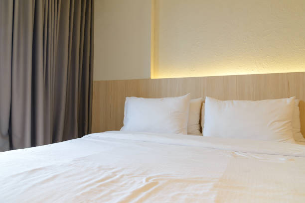 istock stacking of pillows on bed, white bed sheets with wooden bedhead 1222950311