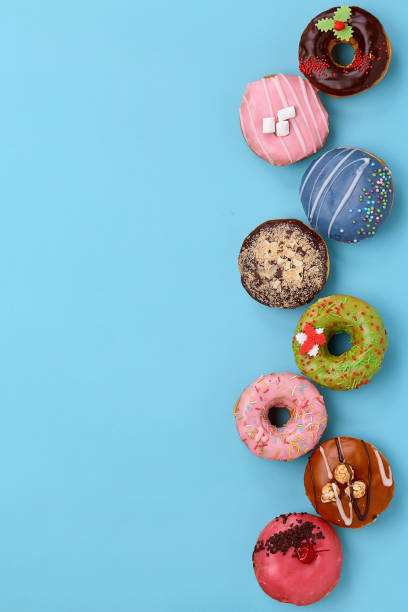 istock Top view of assorted donuts on blue background with copy space. Colorful donuts background. Various glazed doughnuts with sprinkles 1222950869
