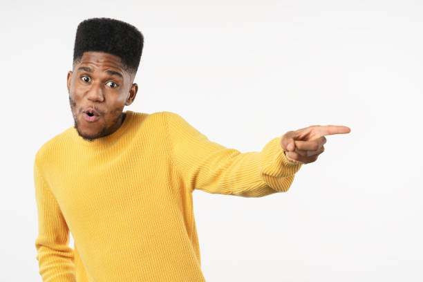 istock Happy african american man pointing to side at copy space on white studio background 1222953511