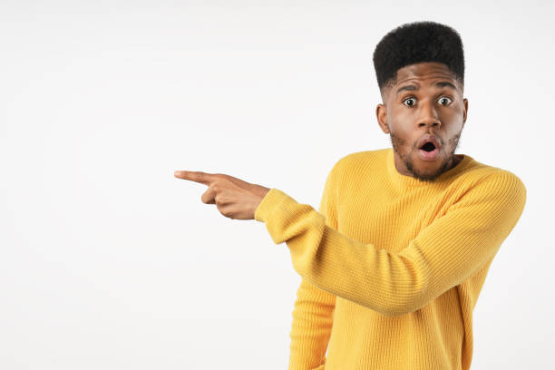 istock Surprised black man pointing finger at copy space isolated on white studio background 1222953692