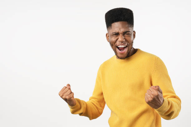 istock Happy young man gesturing winning and keeping mouth open while standing against white background 1222954103