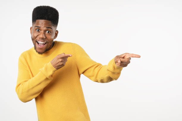istock Cheerful african american man pointing to side at copy space on white studio background 1222954201